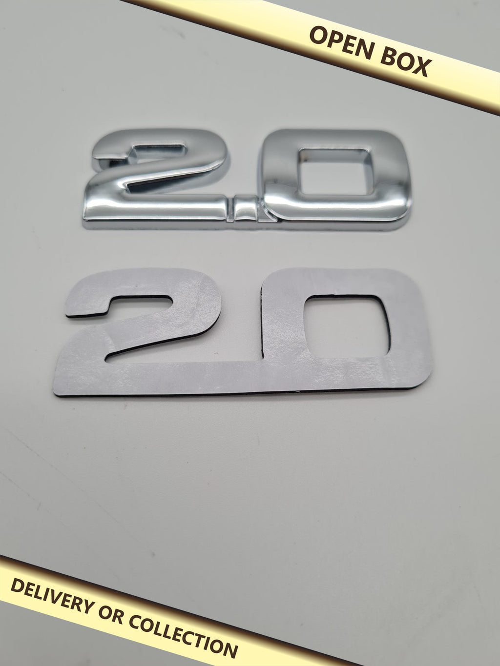 2.0 Car Adhesive Badge Emblem — photograph 1 — Open box; auction delivery information shown on image