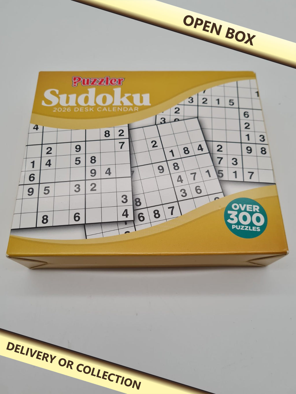 Puzzler Sudoku 2026 Desk Calendar — photograph 1 — Open box; auction delivery information shown on image