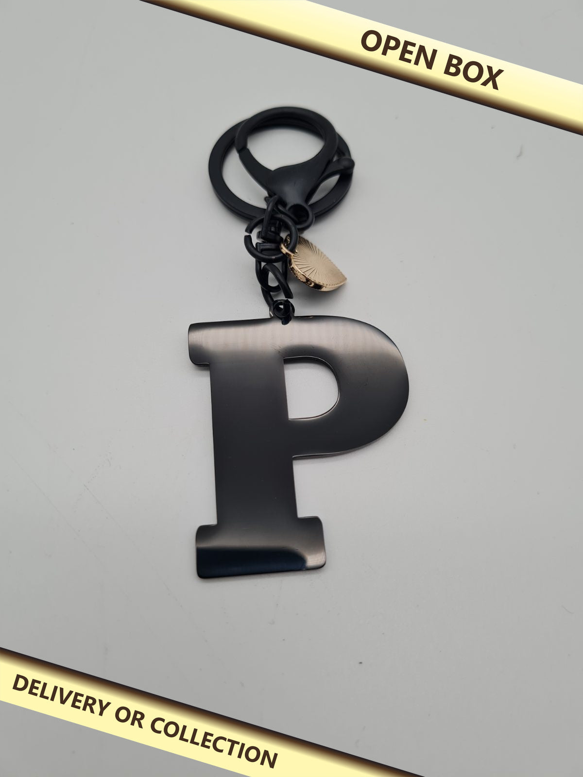 Letter P initial keyring and bag charm — photograph 1 — Open box; auction delivery information shown on image