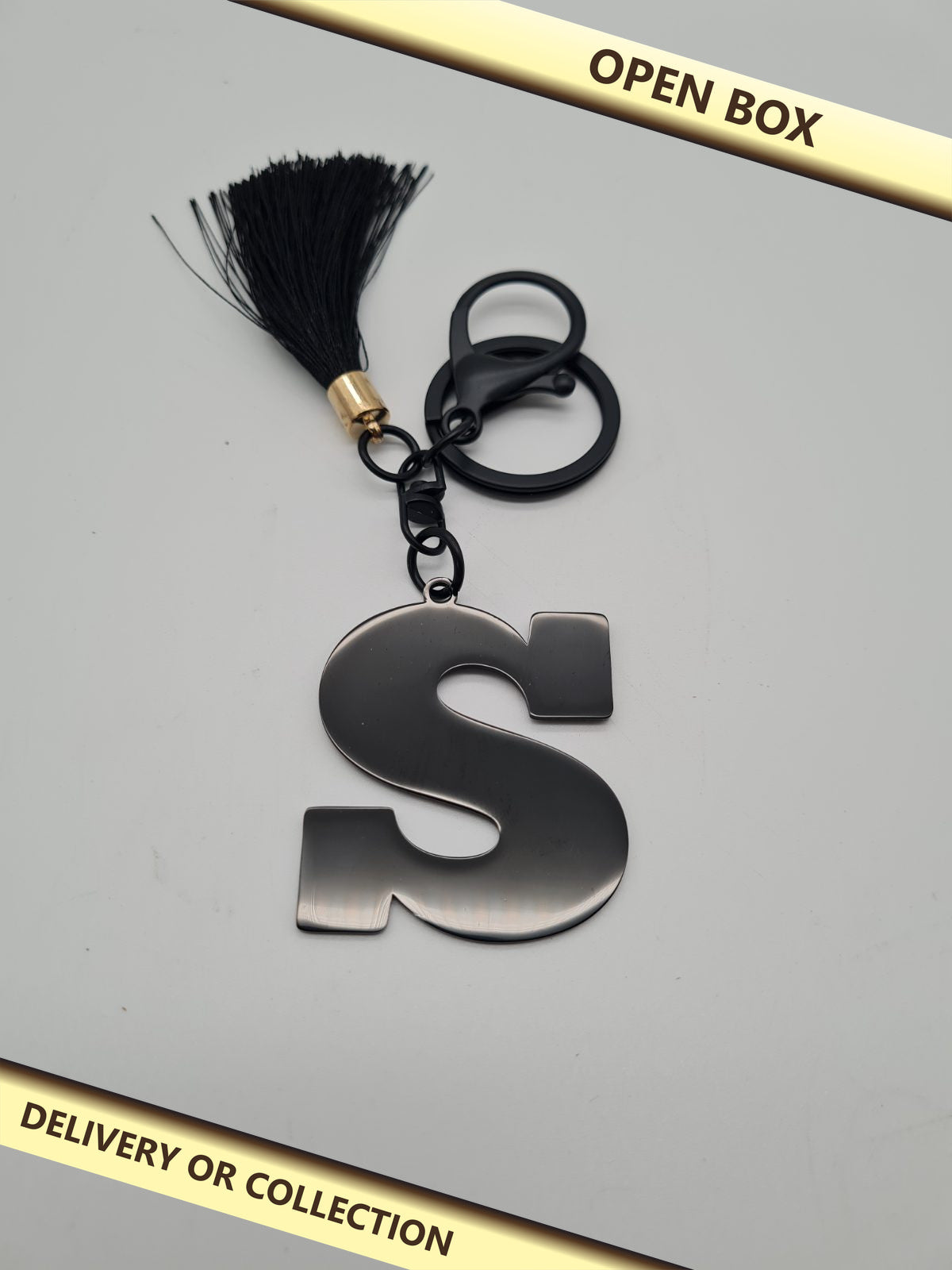 Letter S Initial Keyring with Tassel — photograph 1 — Open box; auction delivery information shown on image