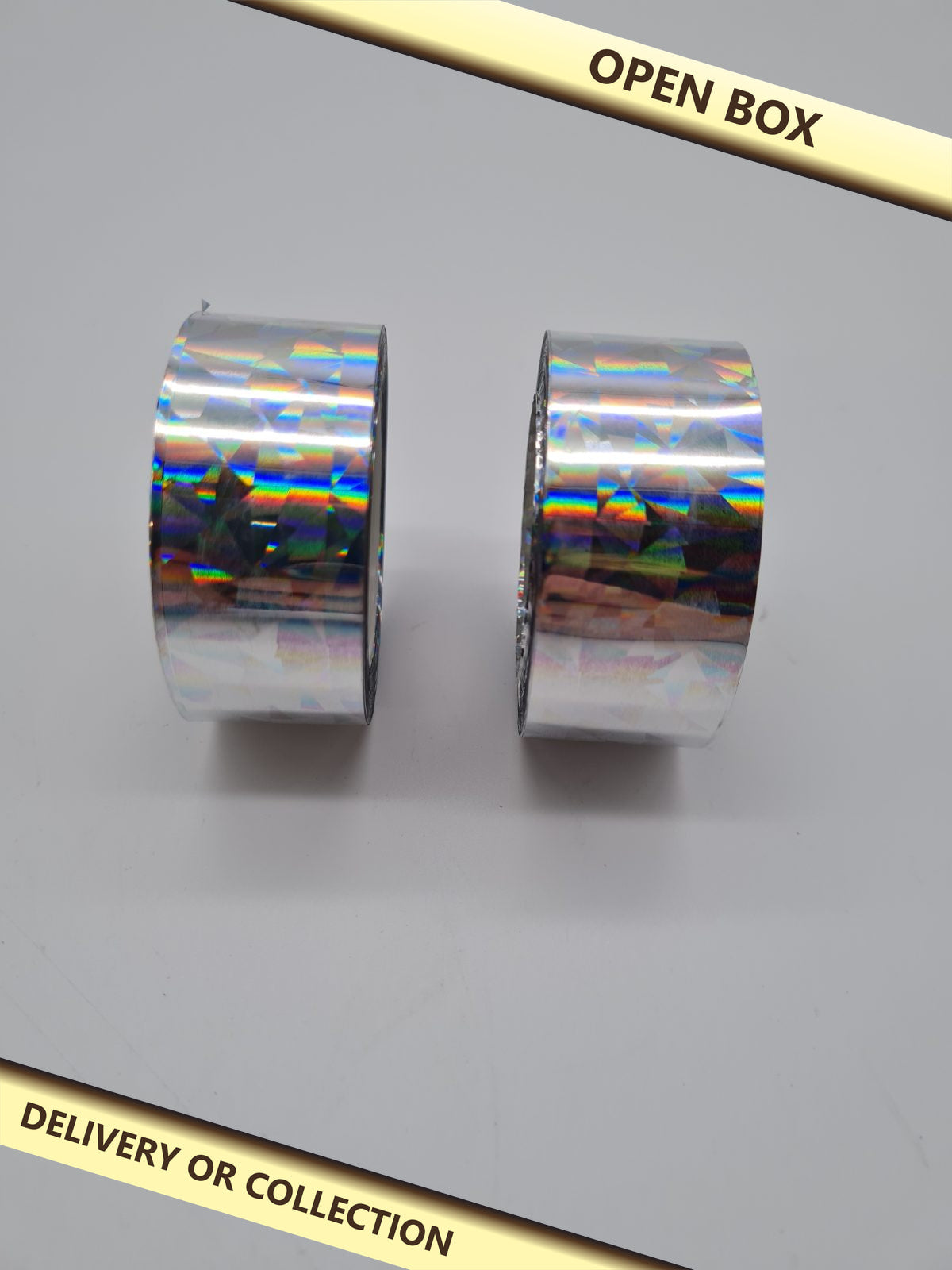 Two rolls of holographic reflective tape. — photograph 1 — Open box; auction delivery information shown on image
