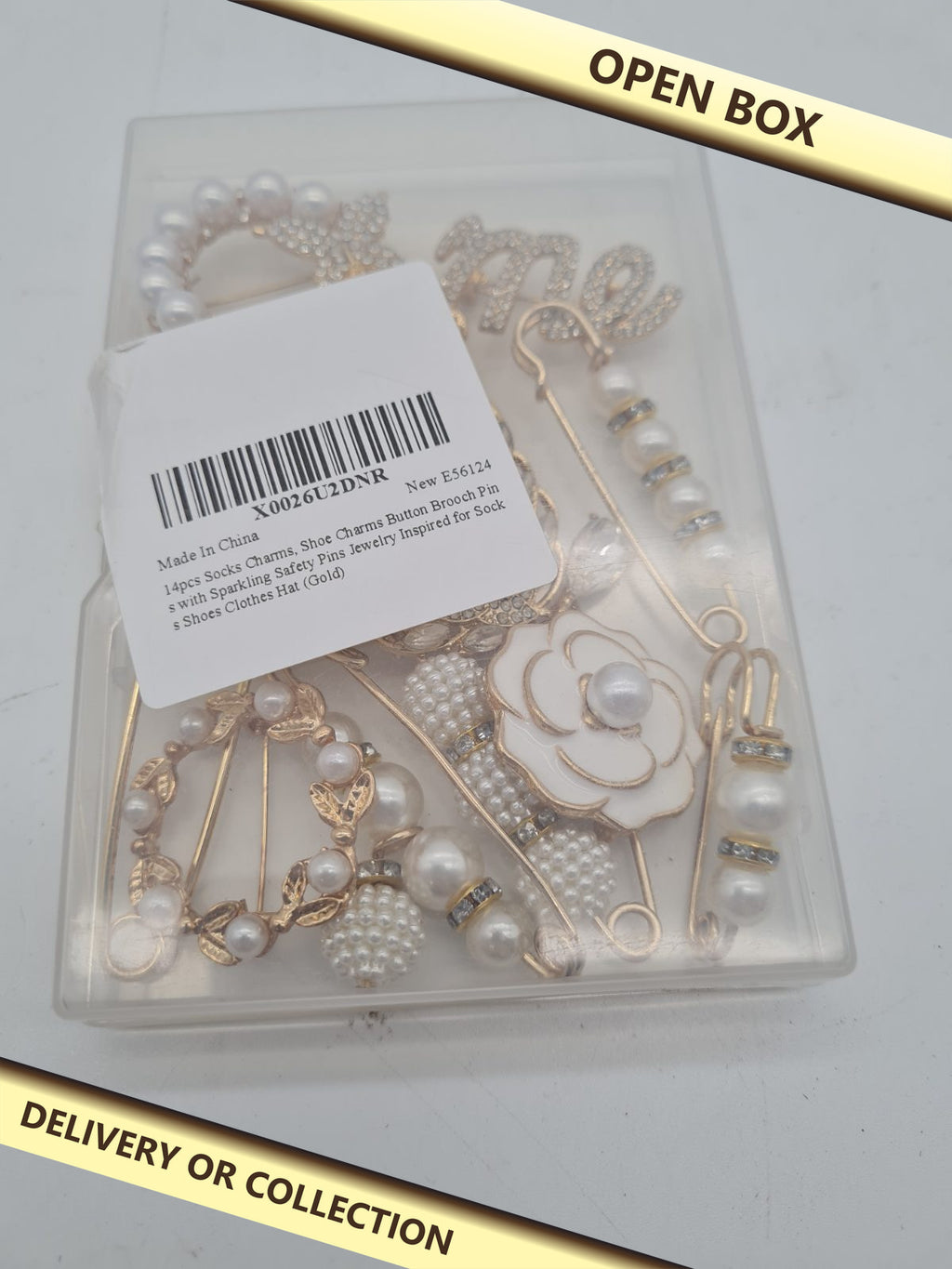 14-Piece Assorted Decorative Brooch and Safety Pin Set — photograph 1 — Open box; auction delivery information shown on image