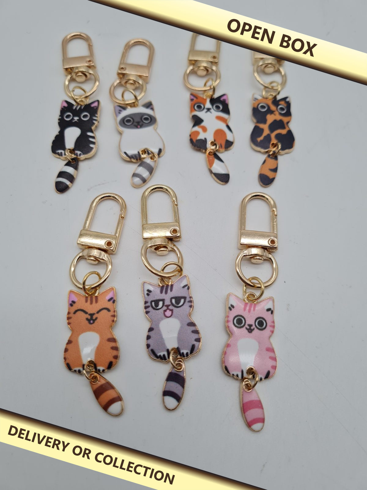 Set of 7 Cat Keyrings — photograph 1 — Open box; auction delivery information shown on image