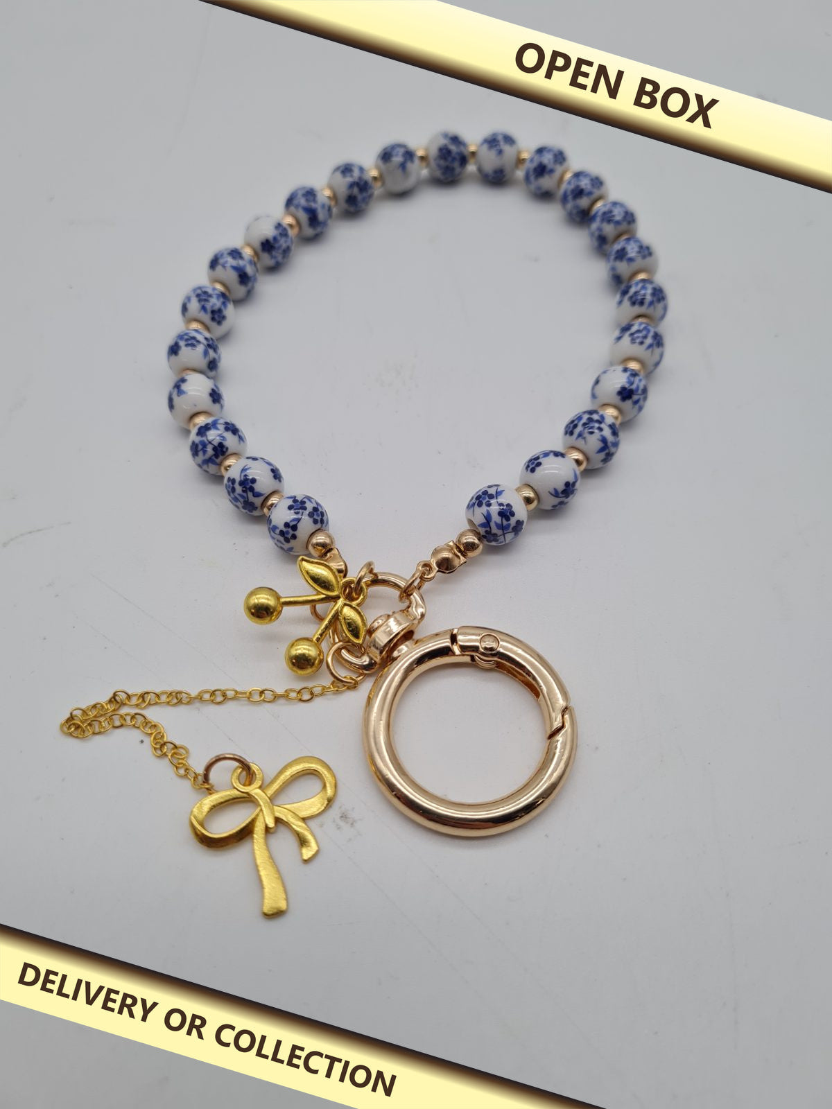 Beaded Wristlet Keychain with Charms — photograph 1 — Open box; auction delivery information shown on image
