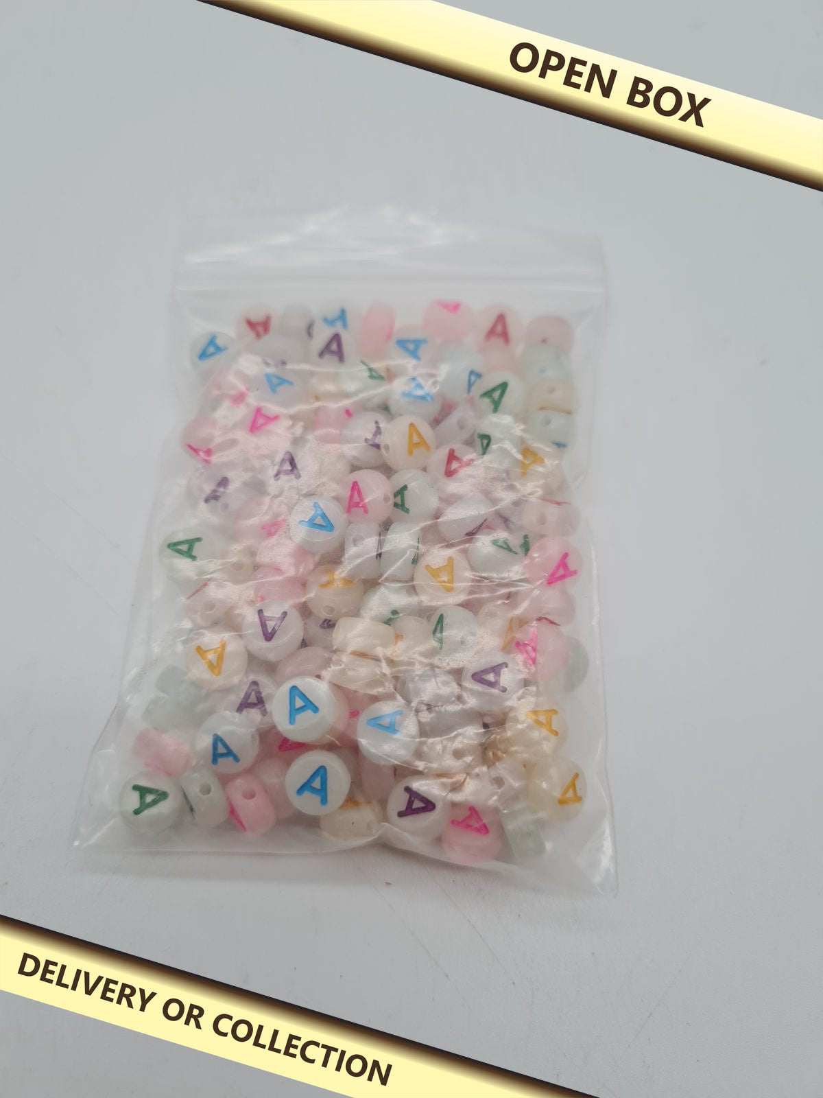 Flat Round Letter A Acrylic Beads — photograph 1 — Open box; auction delivery information shown on image