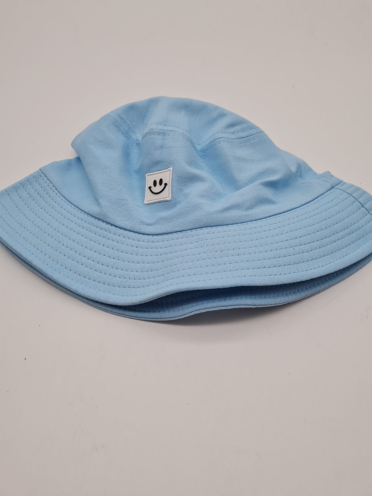 Blue Bucket Hat with Smiley Face Patch — photograph 2