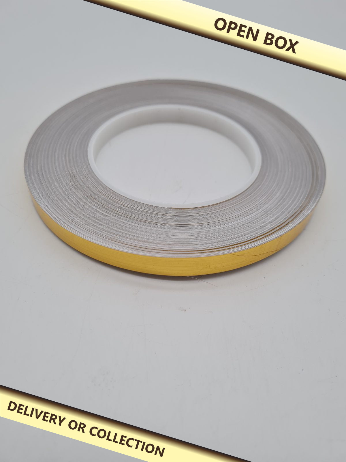 Decorative gold Caulk Strip Tape Roll â€” photograph 1 — Open box; auction delivery information shown on image