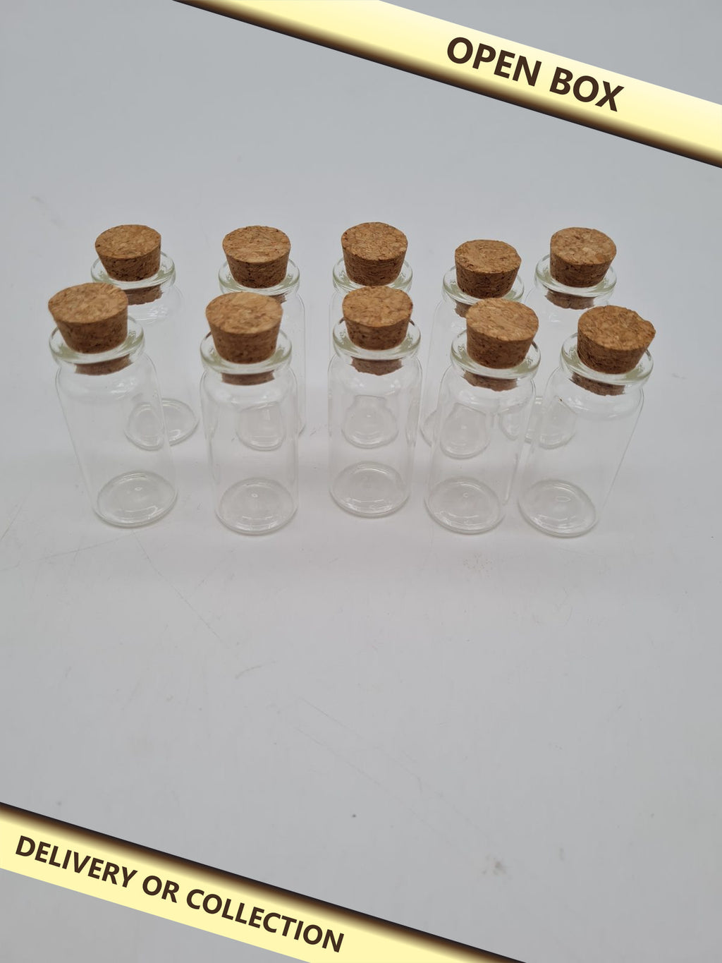 10 Small Glass Vials with Cork Stoppers — photograph 1 — Open box; auction delivery information shown on image