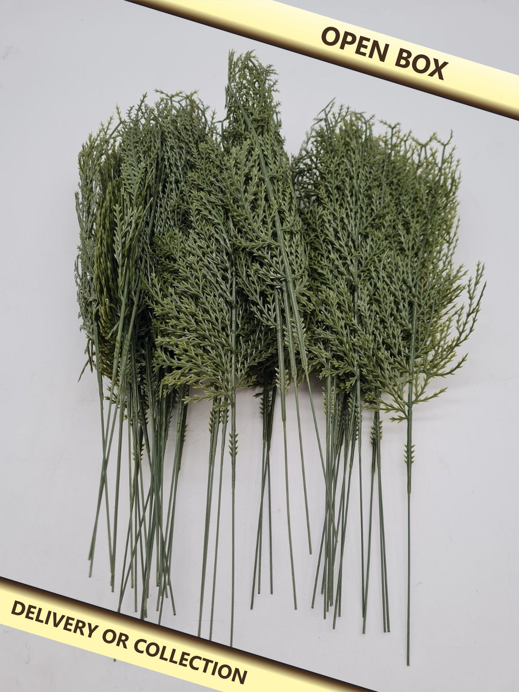 Artificial Conifer Greenery Stems â€” photograph 1 — Open box; auction delivery information shown on image