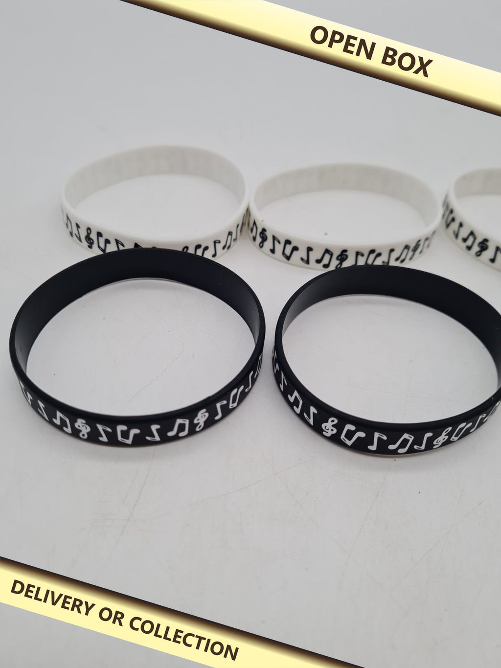 Set of 10 Music Note Silicone Wristbands â€” photograph 1 — Open box; auction delivery information shown on image